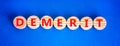 Demerit symbol. The concept word Demerit on wooden circles. Beautiful blue background, copy space. Business and demerit concept