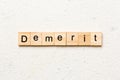 demerit word written on wood block. demerit text on table, concept