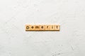 demerit word written on wood block. demerit text on table, concept