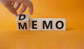 Demo and Memo symbol. Businessman hand turns wooden cube and changes word Memo to Demo. Beautiful orange background. Business and