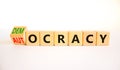 Democracy or autocracy symbol. Turned wooden cubes and changed the concept word Autocracy to Democracy. Beautiful white background