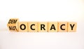Democracy or autocracy symbol. Turned wooden cubes and changed the concept word Autocracy to Democracy. Beautiful white background
