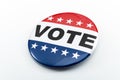 Democracy, presidential election and voting poll concept with red, white and blue vote glossy button pin with stars and stripes Royalty Free Stock Photo