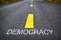 Democracy word on asphalt road