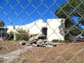 Demolished church behind chain link fence.