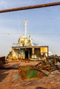 Demolished and rusty deck of a cargo ship with old bridge, mast, antennas and machinery