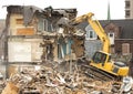 Demolishing a building with a large backhoe Royalty Free Stock Photo