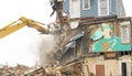 Demolishing a building with a large backhoe Royalty Free Stock Photo