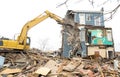 Demolishing a building with a large backhoe Royalty Free Stock Photo