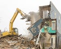 Demolishing a building with a large backhoe Royalty Free Stock Photo