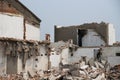 Demolishing site with ruined house and heap with bricks