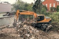 Demolition of building aerial view. Excavator breaks old house. Freeing up space for construction of new building Royalty Free Stock Photo