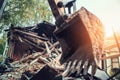 Demolition building construction concept. Excavator shovel or bucket at background of debris broken house Royalty Free Stock Photo