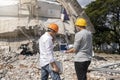 Demolition control supervisor and contractor discussing on demolish building