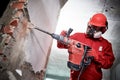 Demolition and construction destroying. worker with hammer breaking interior wall plastering Royalty Free Stock Photo