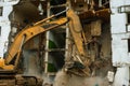 Demolition of a five-story apartment building recognized as emergency housing, close-up of an excavator bucket collects