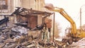 Demolition house using excavator in city. Rebuilding process. Remove equipment Royalty Free Stock Photo