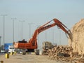 demolition hydraulic crawler excavator removing prats from a hill or a mountain on the roadside to develop and widen the highway