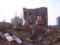 Demolition of the old building in Novosibirsk among the ruins of an excavator