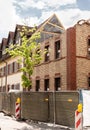 Demolition of an old building. Roof dismantling. Brick walls. Construction fence. Building site. Red bricks. Reconstruction of the Royalty Free Stock Photo