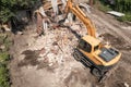 Demolition of old house building process for new construction by excavator bucket, aerial view. City development Royalty Free Stock Photo