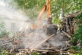 Demolition of old house. Excavator breaks building. City development, construction of new housing on site of old Royalty Free Stock Photo