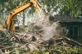 Demolition of old house. Excavator breaks building. City development, construction of new housing on site of old Royalty Free Stock Photo