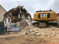 Demolition of an old house with yellow cat Excavator power shovel for building new apartments Royalty Free Stock Photo