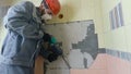 Demolition of old tiles with jackhammer. Renovation of old walls in the bathroom or kitchen