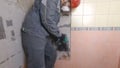 Demolition of old tiles with jackhammer. Renovation of old walls in the bathroom or kitchen Royalty Free Stock Photo