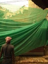 Demolition site covered with huge green cloth