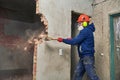 Demolition work and rearrangement. worker with sledgehammer destroying wall