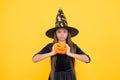 Demoness. jack o lantern. happy halloween. child in witch hat. kid hold spooky pumpkin. witchcraft and enchantment
