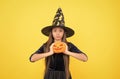 demoness. jack o lantern. happy halloween. child in witch hat. kid hold spooky pumpkin. witchcraft and enchantment