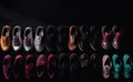 Demonstration of a collection of models of classic shoes in a row, black background. AI generated.