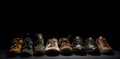 Demonstration of a collection of models of classic shoes in a row, black background. AI generated.