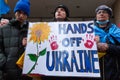 Demonstrators with yellow and blue Ukraine flags and anti-war signs near Russian consulate