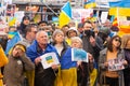 Demonstrators with yellow and blue Ukraine flags and anti-war signs near Russian consulate