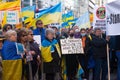 Demonstrators with yellow and blue Ukraine flags and anti-war signs near Russian consulate