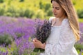 Demure beautiful young woman posing with bunch of lavender Royalty Free Stock Photo