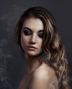 Demure Beauty. Studio concept shot of a beautiful young woman with smoke coming off her.