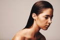 Demure, but cant hide that shine. Studio shot of a stunning young woman wearing gold make up.