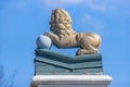 Den Helder, Noord-Holland, Netherlands, April 17, 2021. Side view of a statue of a golden lion with its front legs on a ball Royalty Free Stock Photo