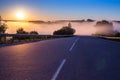 Dence early morning fog in wold at summer highway near river with guard rails Royalty Free Stock Photo