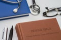 Dengue treatment, symptoms, causes and information written in a medicine book with stethoscope and vintage glasses Royalty Free Stock Photo