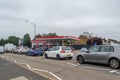 DENHAM, ENGLAND - 25 September 2021: Queue of cars waiting to fill up on fuel outside Esso petrol station amid fuel shortage