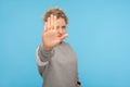Denial, rejection concept. Young woman with short hair in sweatshirt showing stop gesture, no sign Royalty Free Stock Photo