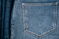 Denim background. Part of blue jeans with back pocket on pile of jeans. Variety of casual trousers and clothes. Top view