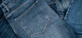 Denim background. Pile of blue jeans. Variety of casual trousers and clothes. Top view to stack of jeans denim