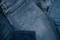 Denim background. Pile of blue jeans. Variety of casual trousers and clothes. Top view to stack of jeans denim